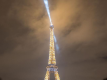 La Torre Eiffel iluminada por la noche con su faro