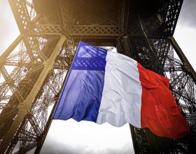 Fotografía de la bandera francesa entre el primer y segundo piso de la Torre Eiffel