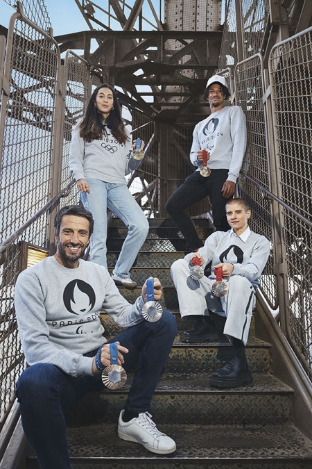 Foto de Tony Estanguet y los atletas posando con las medallas olímpicas en las escaleras de la Torre Eiffel