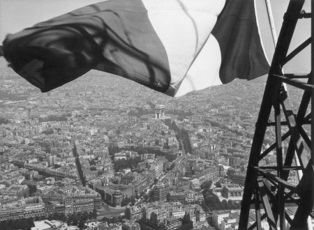 Foto de la bandera tricolor izada en lo alto de la Torre Eiffel.